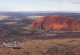 Ayers rock from a helicopter tour and the large rock formation in the flat lands of Australia