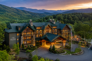 Luxury mountain lodge near Great Smoky Mountains National Park surrounded by forested hills and scenic mountain views at sunset.