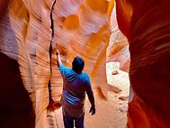 Person hiking in narrow rock passageway at a canyon