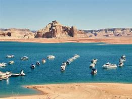 Lake with many boats and canyon in the background with a beach.