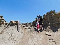 people walking in a desert with backpack
