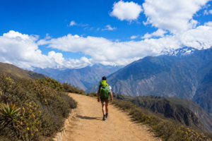 Explore Colca Canyon, Peru: Ultimate Adventure & Vacation Guide 3 Hiker walking along a scenic mountain trail with breathtaking Andean peaks and blue skies near Colca Canyon, Peru.