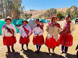 Explore Colca Canyon, Peru: Ultimate Adventure & Vacation Guide 6 Women dressed up for a festival with trees and a mountain on a blue sky day.