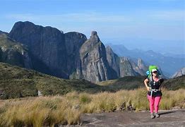 woman walking on a path wearing a backpack in the mountains of Brazil