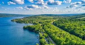 woods and a lake with partly cloudy skies