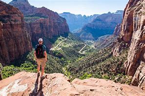 person standing at edge of a canyon with steep cliffs