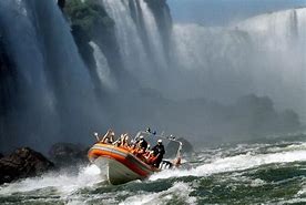 Boat tour at waterfalls with people.