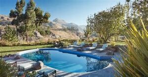 Explore Colca Canyon, Peru: Ultimate Adventure & Vacation Guide 9 Pool at a hotel with trees with mountains on a sunny day.