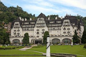 Historic building in Petropolis, Brazil, surrounded by mountains and scenic water features, blending colonial architecture with natural beauty. 🏛️⛰️🌿