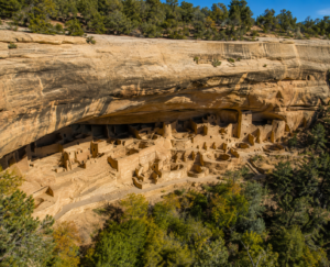Panoramic view of the ancient Cliff Palace at Mesa Verde National Park, Colorado, showcasing remarkably preserved Ancestral Pueblo cliff dwellings built beneath a massive sandstone overhang.