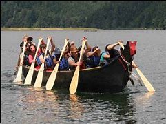 “Plan the Perfect Oregon Vacation: Hiking & Camping at Tahkenitch Falls” 5 Several people Canoeing on a lake with mountains in the background.