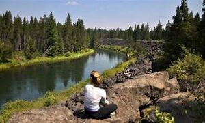woman sitting next to the river