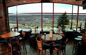 tables and chairs at a restaurant with large windows