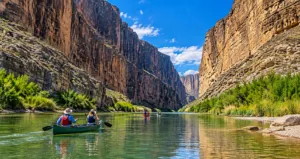 Canoers paddling the Rio Grande through towering canyon walls at Big Bend National Park, Texas.