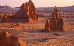 Capitol Reef National Park Guided Tours 3 canyon with steep cliffs in a desert and flat lands with mountains in the background