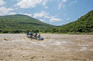 Tugela Falls, South Africa Tour 2 People boating on a river in a jungle on a cloudy sky day.