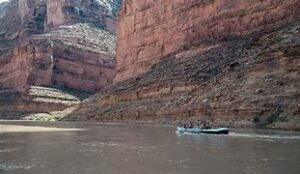 people canoeing on a river in a canyon with steep walls