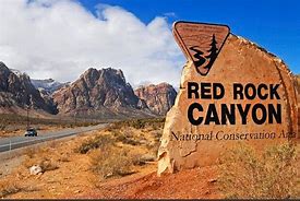Red Rock Canyon sign in a desert with mountains and flat lands