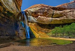 waterfall with steep cliffs in a pool of water on a hot sunny day