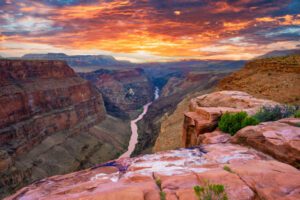 Canyon with steep cliffs with a river that flows through at sunset.