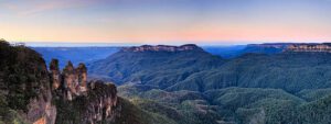 Forest landscape in Australia’s Blue Mountains featuring steep sandstone cliffs, dense eucalyptus trees, and a deep valley below.