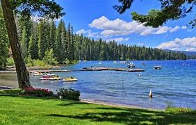 Top 10 Camping Destinations For 2025 3 Lake with boats in a forest and a partly cloudy sky