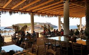 Top 10 Camping Destinations For 2025 6 Restaurant with people at table and chairs near a lake and mountains