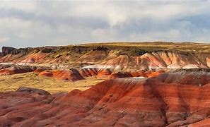 Steep canyon with different color and a cloudy sky.