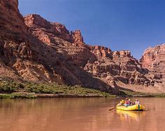 Explore the Best West Canyon Adventures: Top 15 Camping & Hiking Destinations ?⛺ 6 People canoeing on a river in a canyon with steep walls and a blue sky.