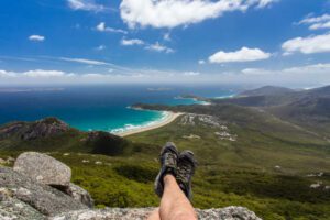 ? Wilsons Promontory National Park, Victoria: Australia’s Coastal Wilderness Adventure ?? 2 Wilsons Promontory National Park, Victoria: Ocean view with beach and rainforest and persons feet sticking over a ledge