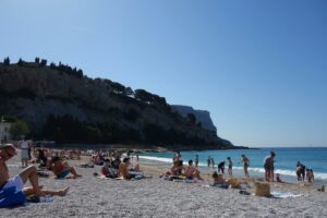 people laying on beach towels at the beach and the ocean in front of them