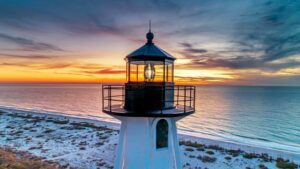 Gasparilla Island (Boca Grande): Historic Charm & Gorgeous Beaches 3 Beach with a lighthouse beside the ocean, surrounded by sand and coastal scenery.