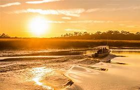 Boast on the water at a beach at Sunset.