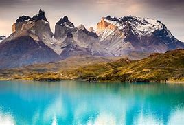 a lake with mountains and brown vegetation