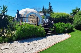 Galápagos Islands, Ecuador: Luxury Glamping Among Unique Wildlife✨ 3 Glamping structure with a rock brick path and shrubs and chairs.