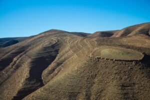 Large mountains with steep walls on a clear blue-sky day.