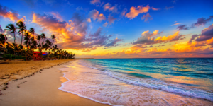 Tropical beach coastline at sunset featuring golden sand, turquoise ocean waters, gentle waves, swaying palm trees, colorful clouds, and a vibrant island paradise atmosphere.