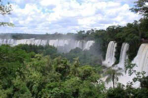 Iguazú Falls, Argentina & Brazil: Glamping Near One of the World’s Greatest Waterfalls 2 Waterfall in a rainforest of trees and vegetation on a cloudy day.