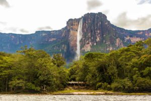 Venezuela’s Canaima National Park Eco-Lodges: Glamping Beneath Angel Falls 1 Mount Roraimsa Venezuela in a rainforest with a waterfall and river.