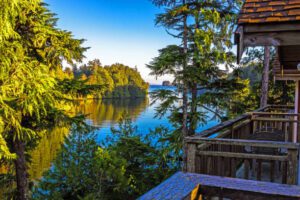 Glamping Hub Treehouses – Vancouver Island, Canada 1 Glamping structures with a railing on a porch in forest and lake