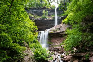 Two tier waterfalls with rock walls and trees