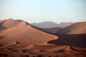 Desert with tall sand dunes on a hazy day.