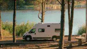 Harriman State Park, NY: Lakes, Trails & Wilderness Just Outside NYC ✨ 4 Camper van parked beside a peaceful lake surrounded by trees, representing RV and camper travel near Harriman State Park, New York.