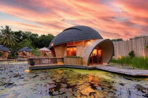 Eco Lodge Bungalow, Prainha – Serenity By The Sea 5 Glamping dome on a platform over the water with a wooden walkway and fence, with other domes in the background.