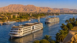 Karnak Temple – Luxor, Egypt: Gateway To Ancient Wonders 5 Nile River cruise ships sailing near Luxor, Egypt, surrounded by palm trees, desert mountains, traditional sailboats, and scenic river landscapes.