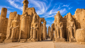 Karnak Temple – Luxor, Egypt: Gateway To Ancient Wonders 12 Ancient statues of pharaohs at Karnak Temple in Luxor, Egypt, surrounded by towering sandstone columns, hieroglyph-covered walls, and temple ruins.