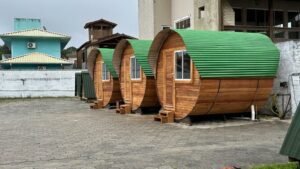 Three round glamping units and a building and tower,