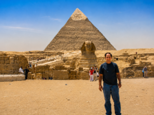 ⛵ Nile River Cruises – Sail Past Temples & Scenic Landscapes 9 Traveler visiting the Great Sphinx and Pyramids of Giza during a vacation in Egypt.