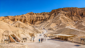 Karnak Temple – Luxor, Egypt: Gateway To Ancient Wonders 18 Wide panoramic view of the Valley of the Kings near Luxor, Egypt, featuring rugged desert mountains, ancient tomb entrances, and visitors exploring the archaeological site.