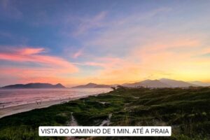 Tranquil sunrise at a beach near the ocean with trees and mountains.